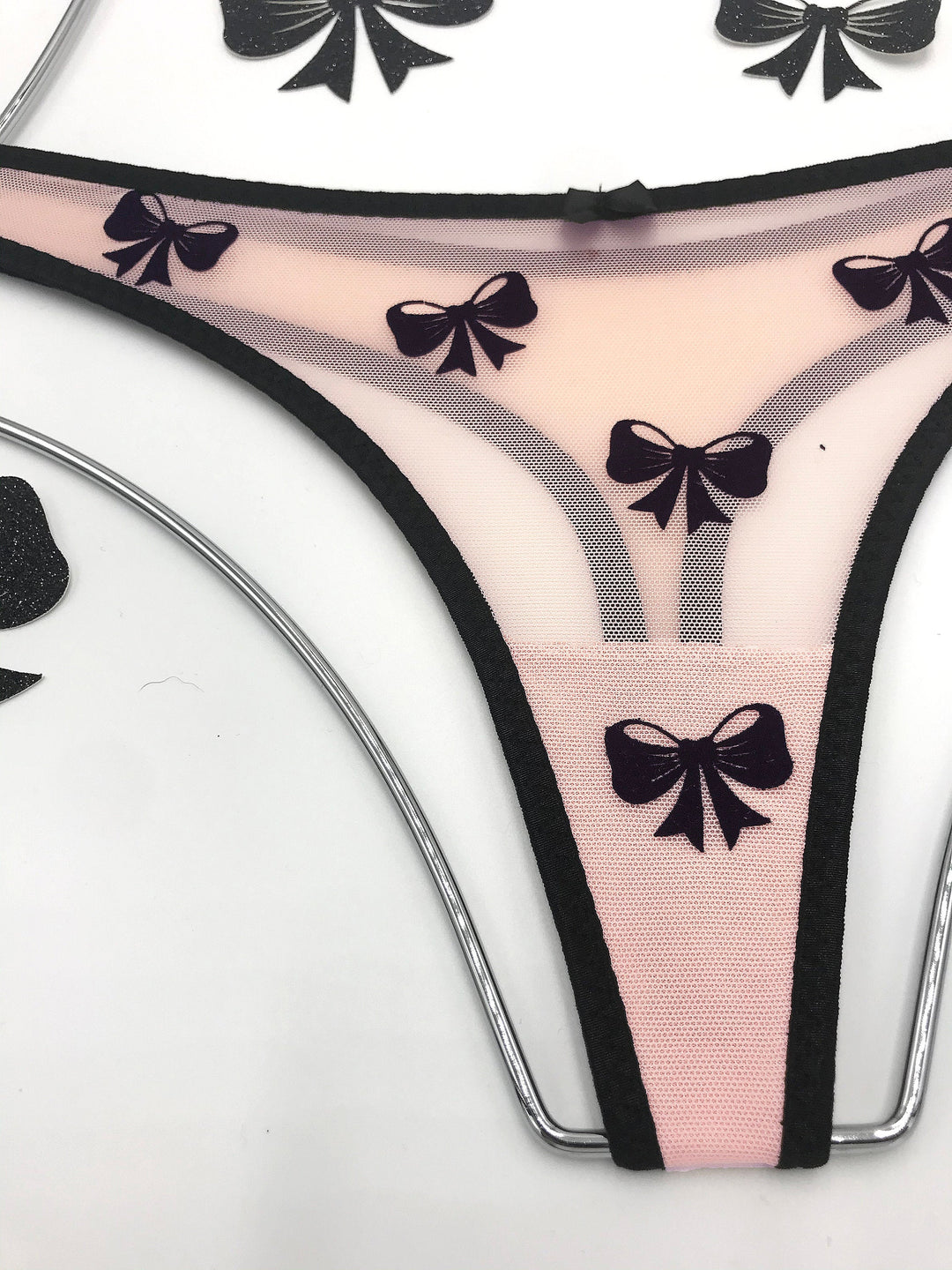 Peach sheer mesh thong with black velvet bow applique